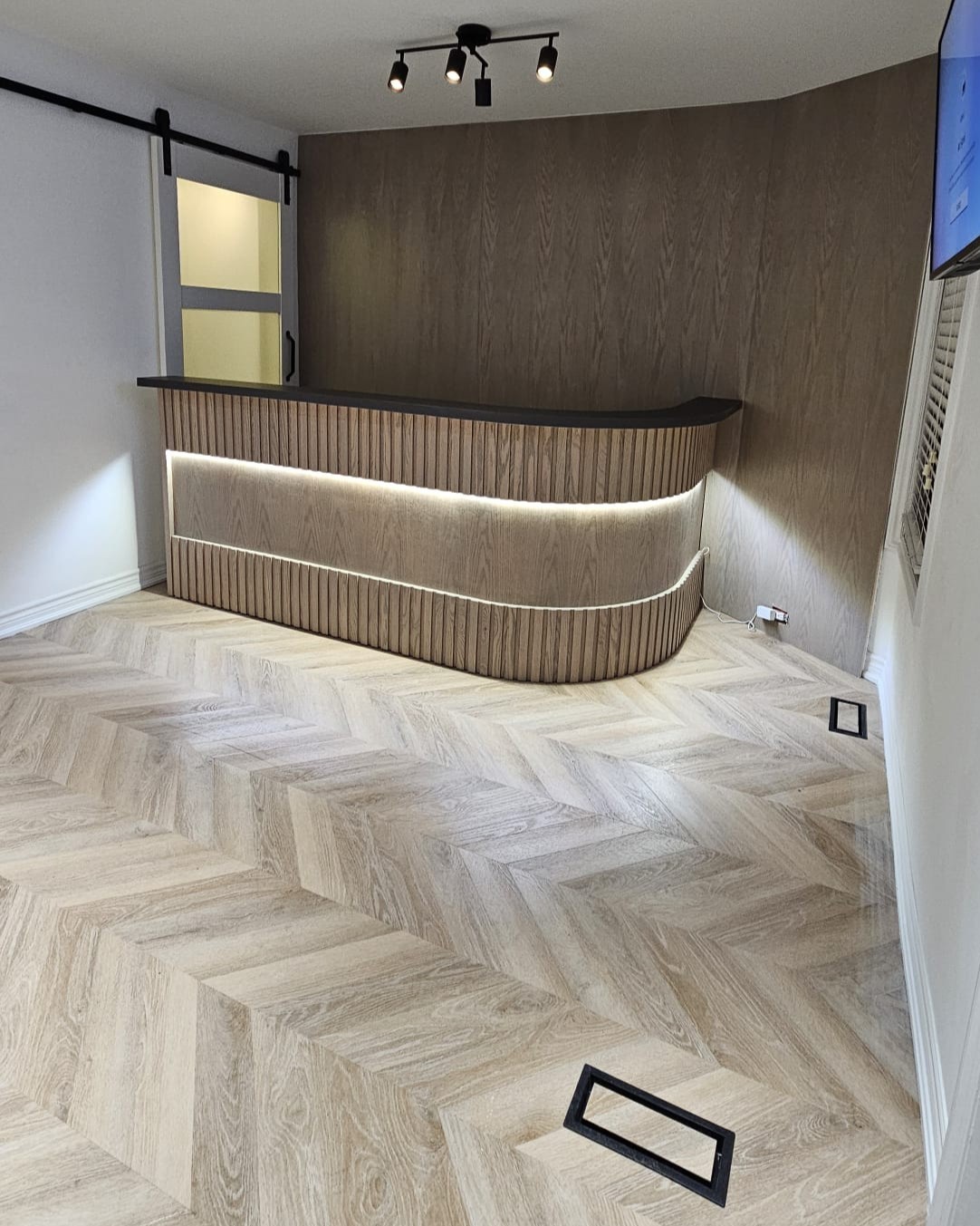 Fully remodeled room featuring custom modern reception desk in Toronto clinic