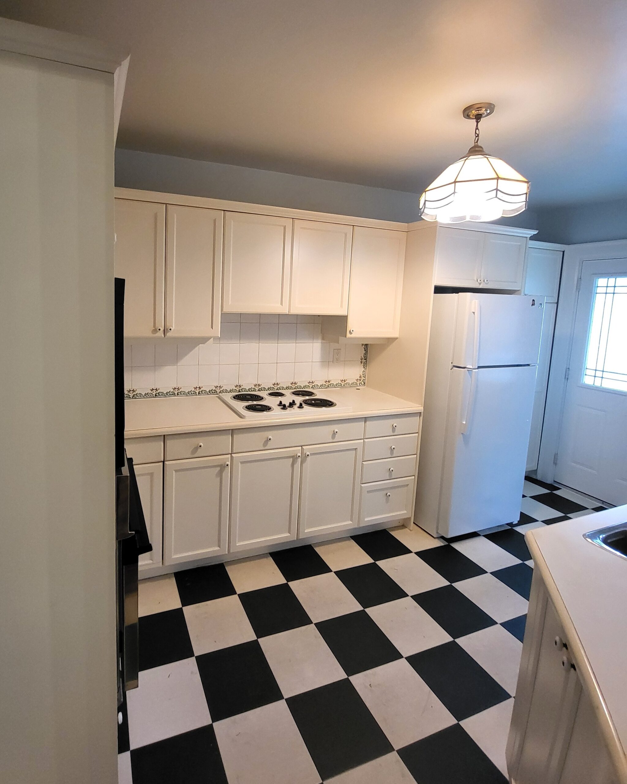 Original kitchen cabinets and flooring before renovation in Midtown Toronto