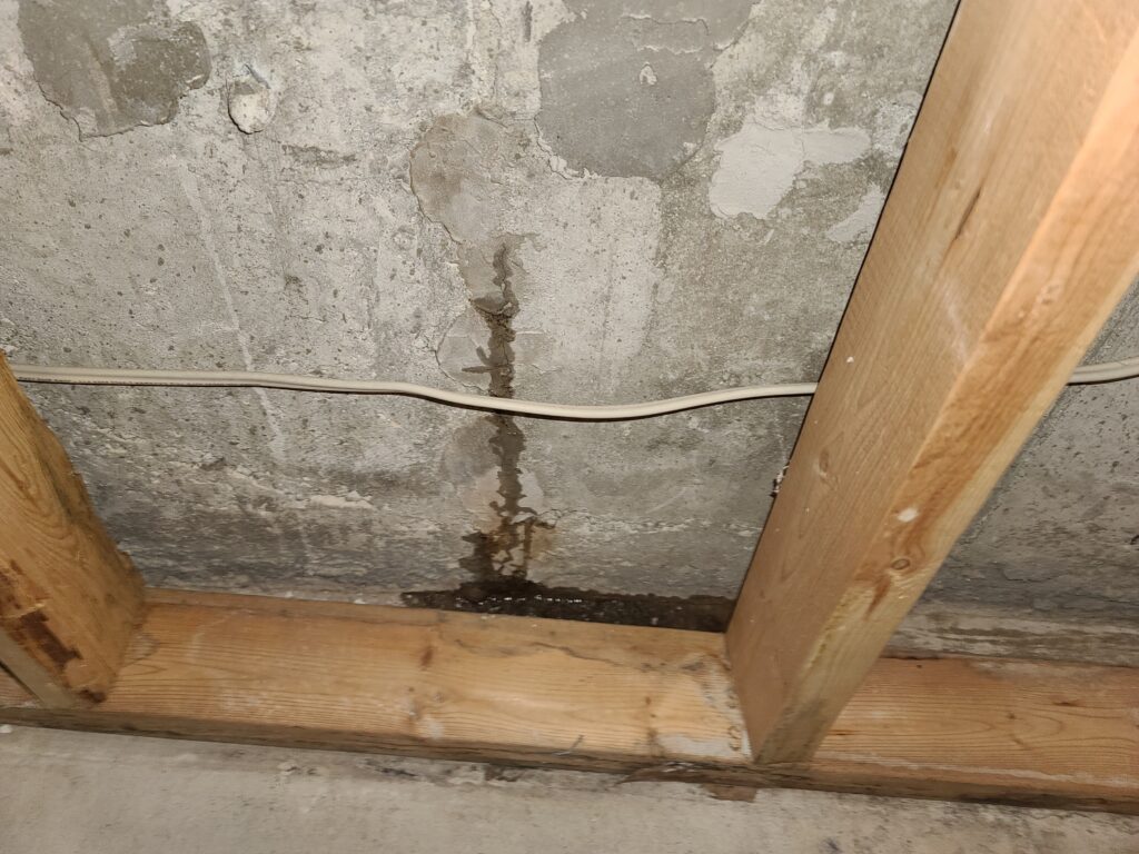 Water leaking through the foundation wall, indicating penetration into the basement interior