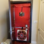Blower door assembly installed in a doorway for air pressure testing