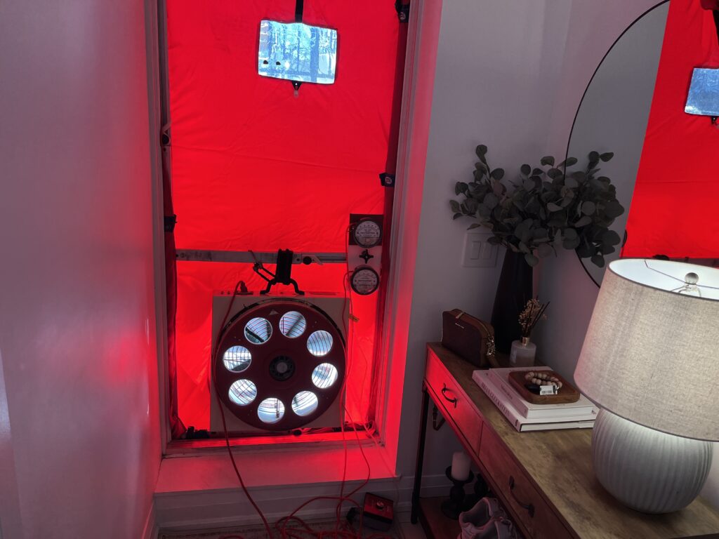 Blower door assembly set up at the main entrance door to create negative indoor pressure for leak detection