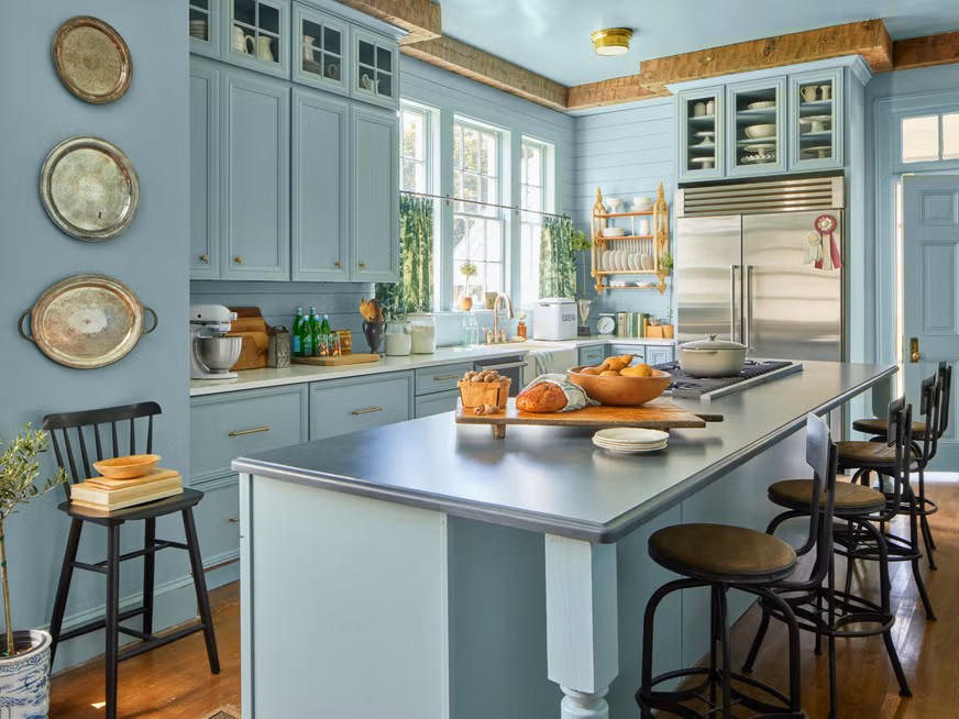  A bold kitchen design using color drenching with matching cabinets, walls, and accents in a single vibrant hue