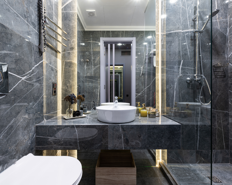luxury bathroom with dark walls, black fixtures, and moody lighting accents