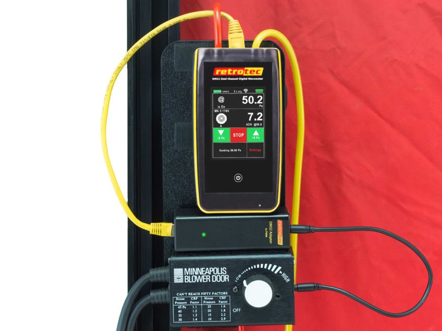 Digital pressure gauge used to measure air pressure during blower door testing