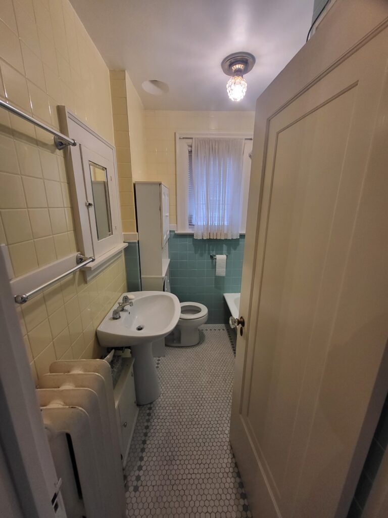 aged bathroom featuring original cast iron tub, old tiles, and vintage plumbing fixtures