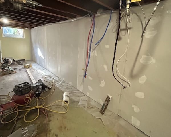 Drywall installation and joint mudding in progress during basement finishing