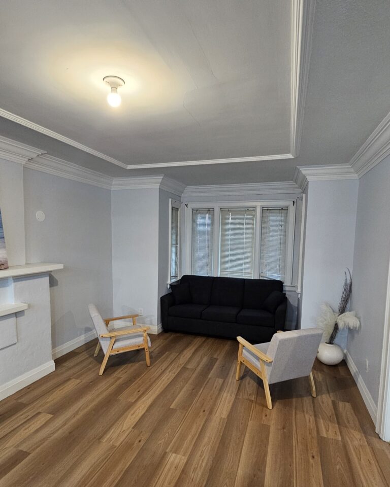 Renovated living area with open-concept design, modern flooring, and updated lighting fixtures