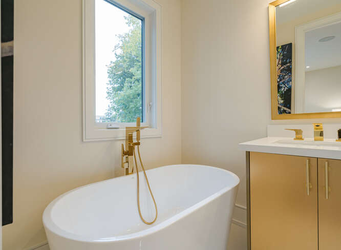 Luxury bathroom renovation in Midtown Toronto with modern freestanding bath tub and gold fixtures by Olive Contractors, showing upgrades that increase renovation budget