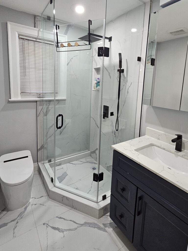 Renovated bathroom in Midtown Toronto with glass shower, marble tiles, and modern vanity by Olive Contractors