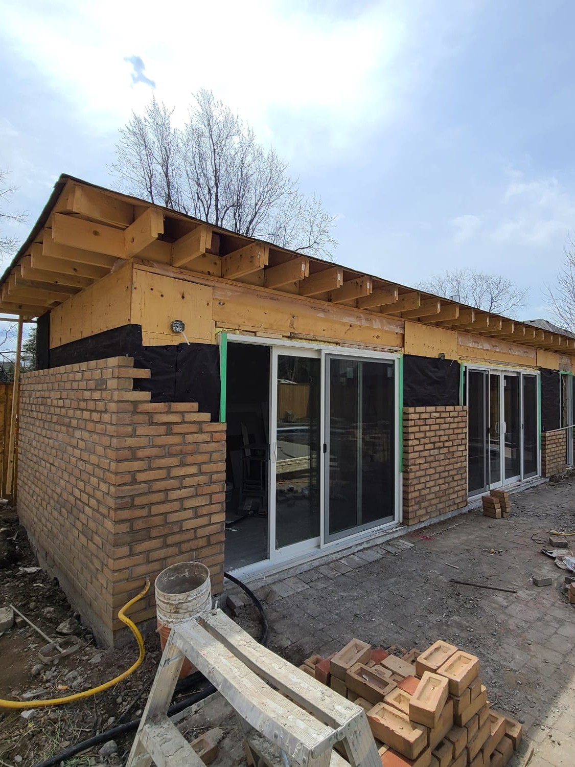 Exterior brick installation in progress on custom cabana house built in Central Ajax by Olive Contractors.