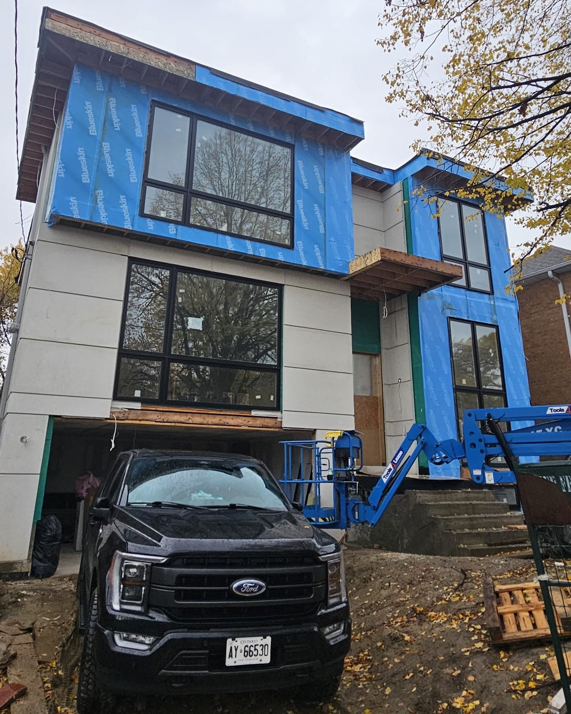 Exterior wall cladding installation in progress on a custom house project in Toronto, showcasing modern materials and professional construction work.