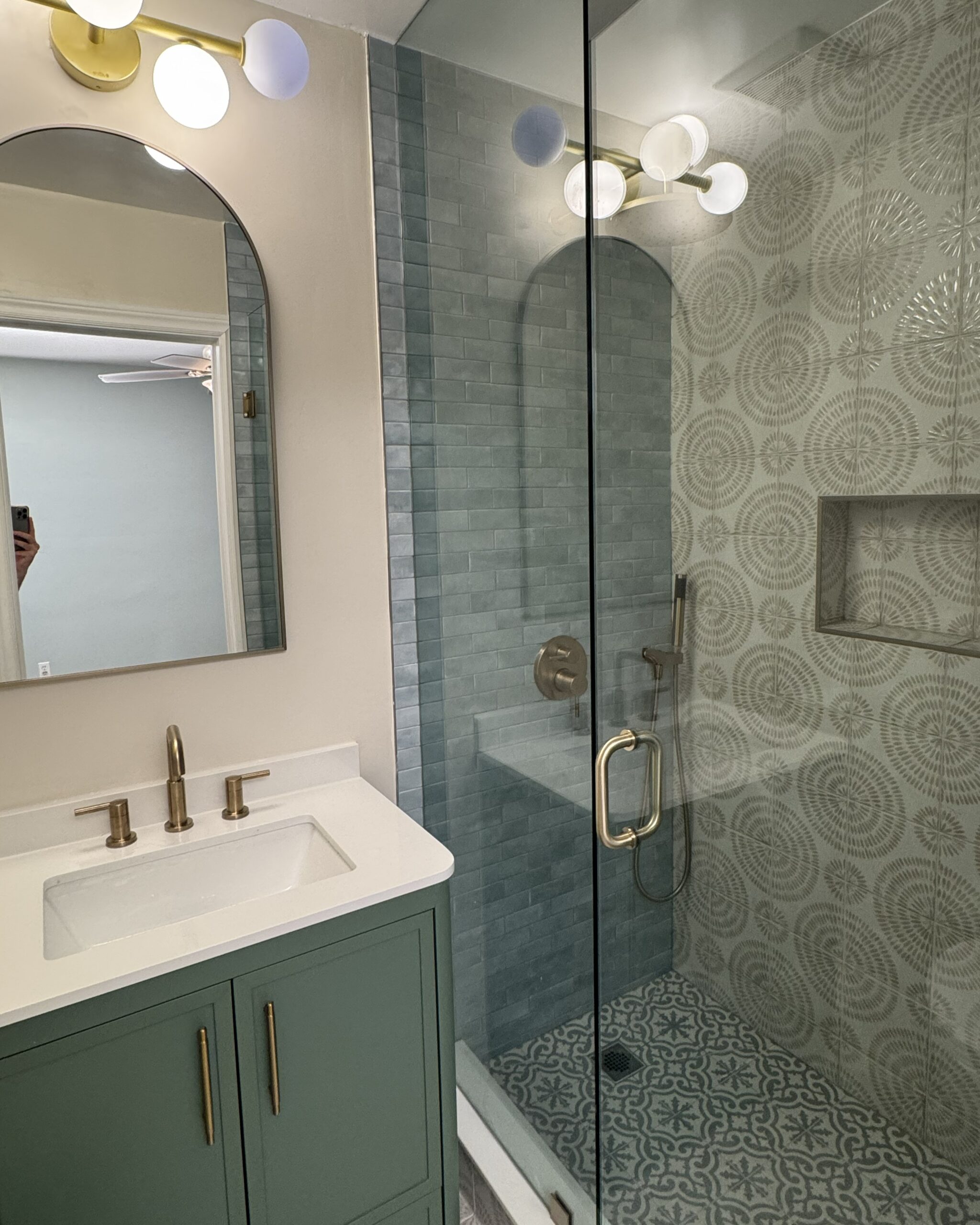 Completed ensuite bathroom renovation featuring green vanity, walk-in shower with patterned tiles, and brushed brass fixtures in Toronto hom