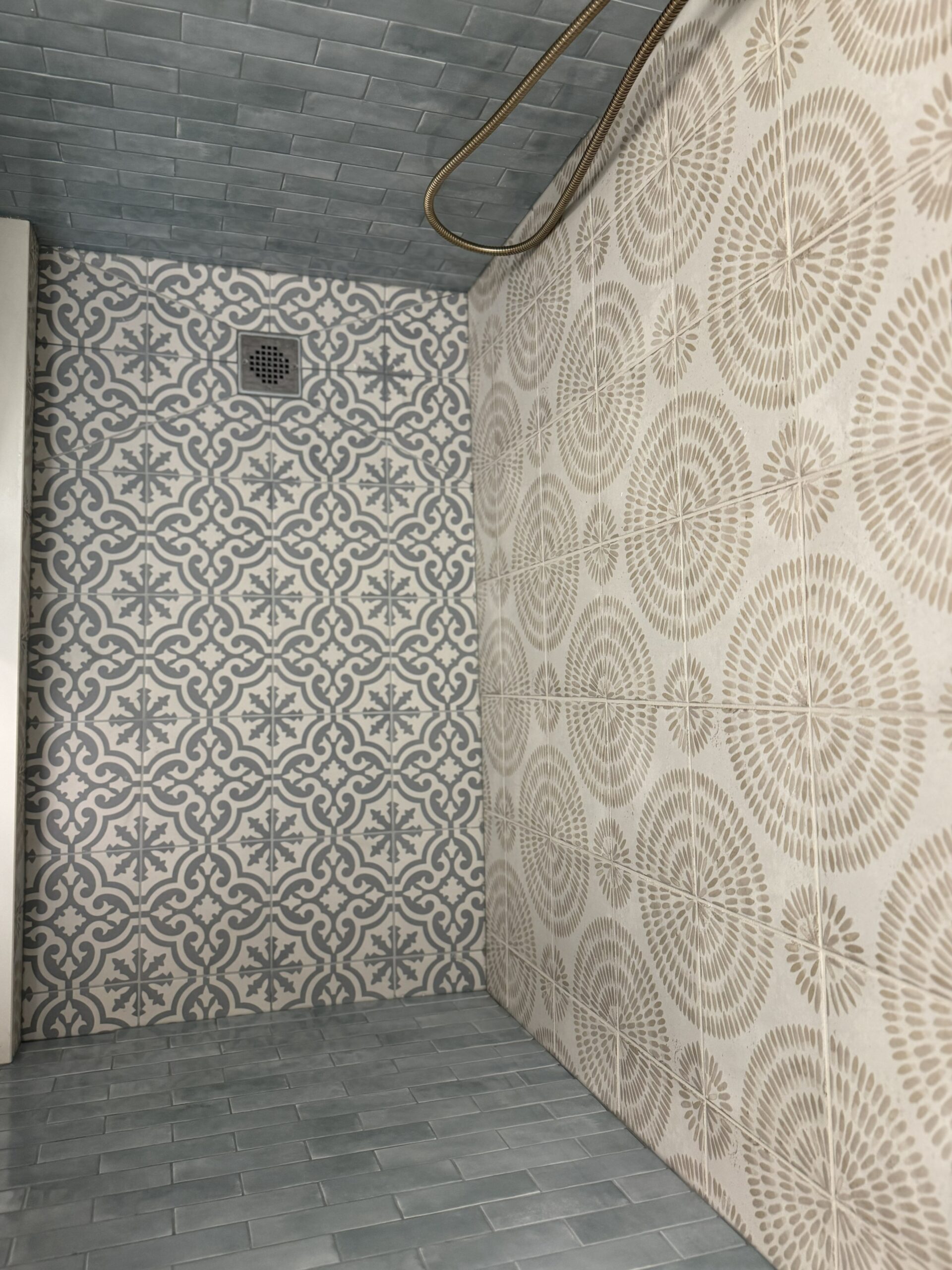 Renovated ensuite walk-in shower with Moroccan encaustic floor tile and botanical patterned wall tile in Toronto home