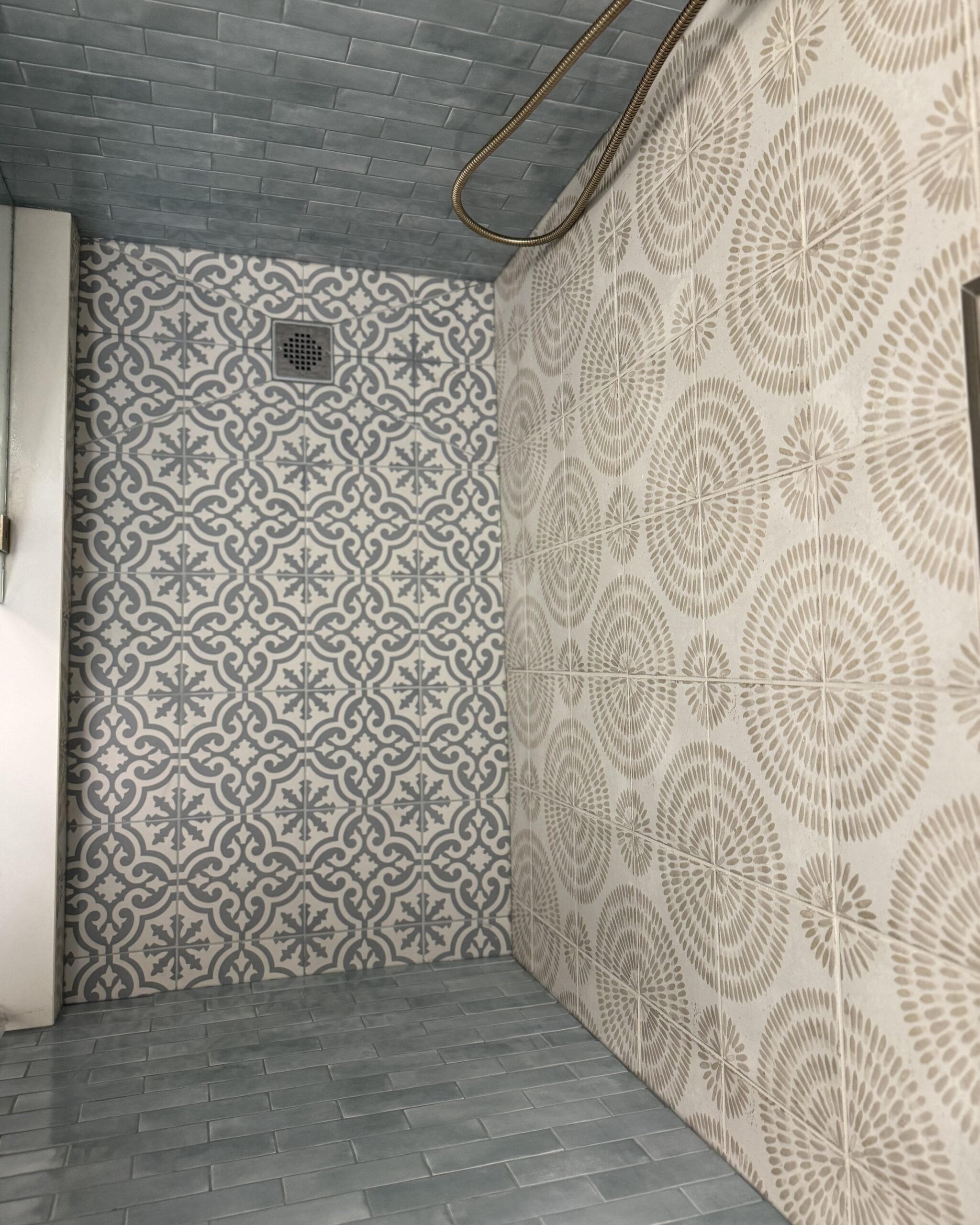 Renovated ensuite walk-in shower with Moroccan encaustic floor tile and botanical patterned wall tile in Toronto home