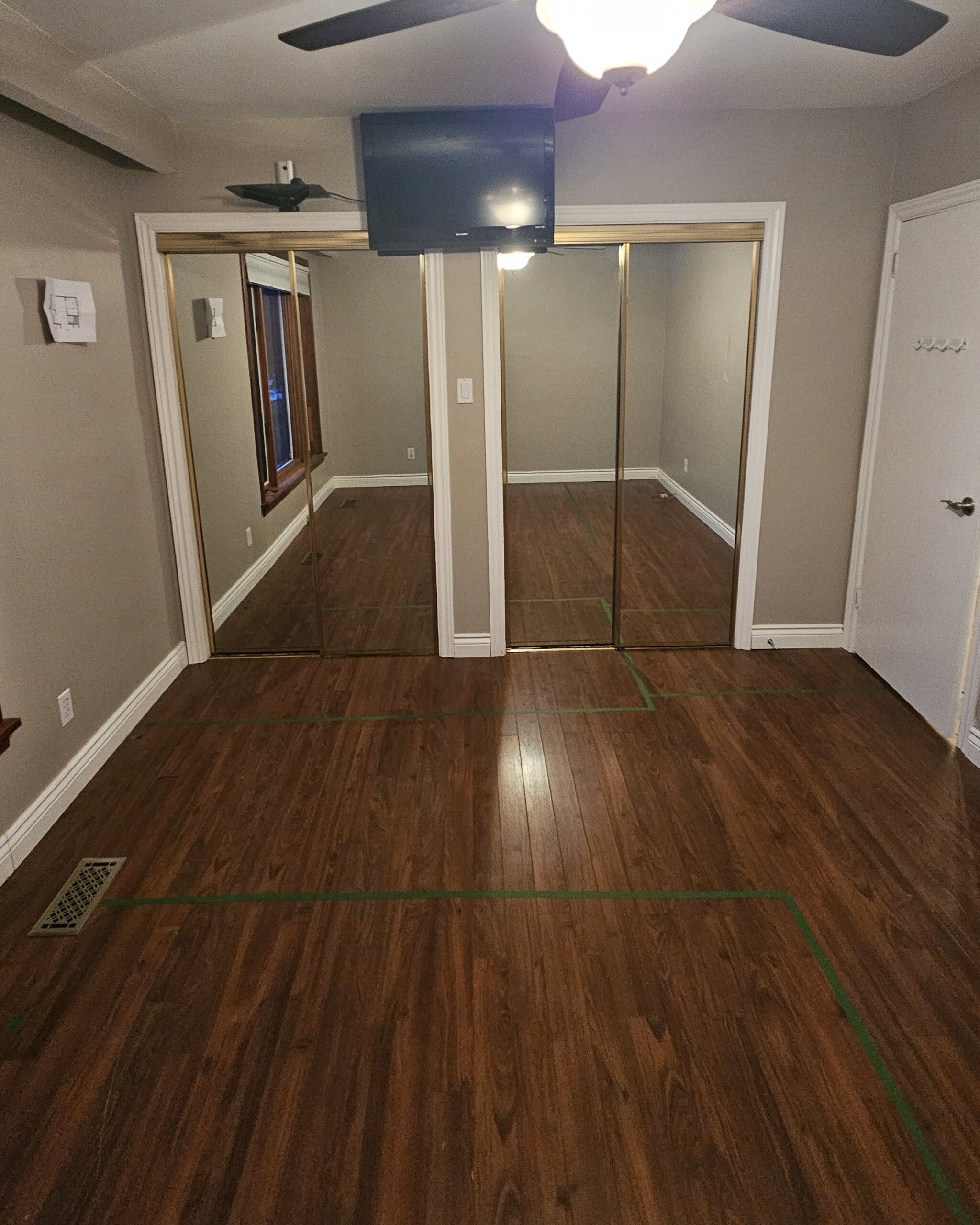 Master bedroom before renovation showing outdated mirrored sliding closet doors in GTA home