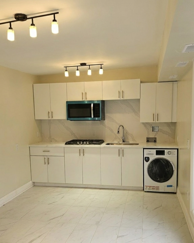 White shaker kitchen with quartz countertops and marble porcelain tile in a backyard cabana unit Toronto