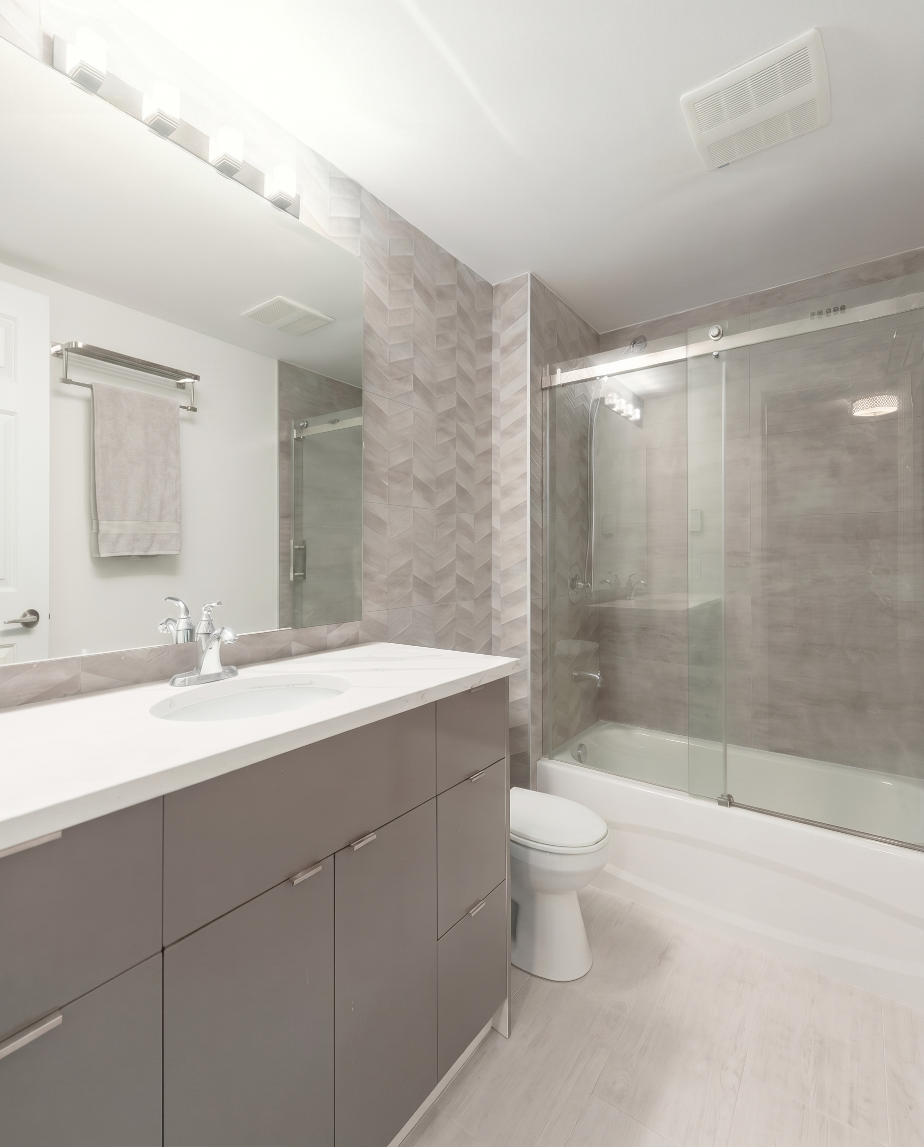 Contemporary bathroom renovation with quartz countertop, custom vanity, and upgraded lighting in North York, ON